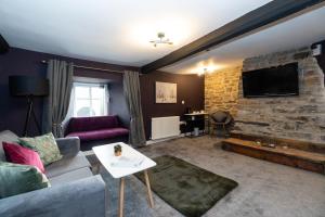 a living room with a couch and a stone fireplace at The Ancient Unicorn in Barnard Castle