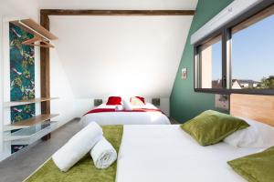 2 łóżka w pokoju z zielonymi ścianami w obiekcie Gites Spa Strasbourg - Villa Lion - SPA Privé, Sauna, Borne d'arcade, Babyfoot w mieście Ittenheim +37 zdjęć