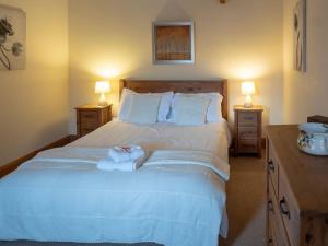 a bedroom with a large white bed with two lamps at Wheelhouse Cottage . A brick-built barn conversion in Thirsk