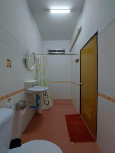 y baño con lavabo, aseo y espejo. en Rutcha homestay Betong รัชชา โฮมสเตย์ เบตง en Betong