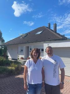 a man and a woman standing in front of a house at Heidi´s Lerchennest in Weikersheim