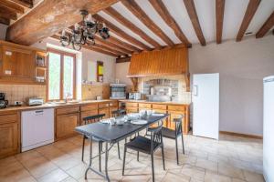 eine Küche mit einem Tisch und Stühlen in der Unterkunft Crazy Villa Ricardière 89 - Indoor heated pool - Basket - 2h Paris - 30p in Charny