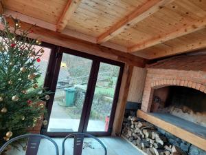 a screened porch with a fireplace and a christmas tree at VILLA KORANA in Barilović
