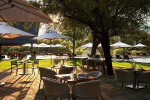 a restaurant with tables and chairs and umbrellas at Letamo at Qwabi Private Game Reserve by NEWMARK in Bela-Bela