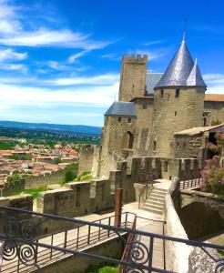 SURDESPINE Historic 4 Châteaux Lastours 3 star air conditioned في Lastours: قلعة كبيرة بها درج يؤدي إليها