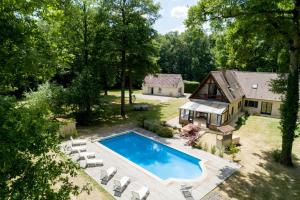 - une vue aérienne sur une arrière-cour avec une piscine et une maison dans l'établissement Crazy Villa Ecottay 61 - Heated pool & sauna - 2h from Paris - 30p, à La Loupe