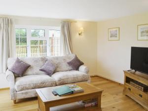 a living room with a couch and a coffee table at Paddock Cottage in Orford