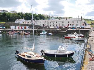 two boats are docked in a harbor with buildings at Island View in Dunure