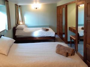 1 Schlafzimmer mit 2 Betten und einem Spiegel in der Unterkunft Meadowside Cottage in Calton