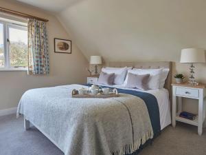 a bedroom with a large bed with a blue blanket at Hungate Garden Cottage in Pickering