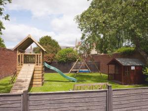 a backyard with a playground with a slide at Hungate Garden Cottage in Pickering