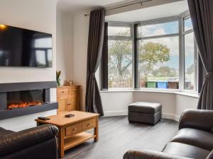 a living room with a couch and a fireplace at Excalibur Cottage in Saint Annes on the Sea