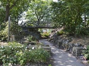 a path with a wooden bridge over a stone wall at Excalibur Cottage in Saint Annes on the Sea