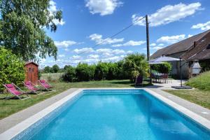a swimming pool with two chairs and a house at Crazy Villa Gouadiere 45 - Heated pool - Basket - 1h45 from Paris - 30p in Poilly-lez-Gien