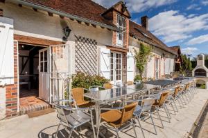 a row of tables and chairs outside a building at So Villa Bergerie 45 - Heated pool - Soccer - Jacuzzi - 1h30 from Paris - 30 beds in Saint-Maurice-sur-Aveyron