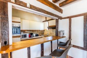 eine Küche mit einer Holztheke und 2 Stühlen in der Unterkunft So Villa Bergerie 45 - Heated pool - Soccer - Jacuzzi - 1h30 from Paris - 30 beds in Saint-Maurice-sur-Aveyron