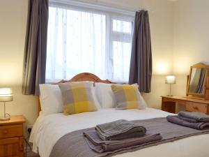 um quarto com uma cama e uma janela grande em Rosevene em Cardigan