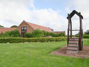 a park with a bench in front of a building at Oregano - E4483 in Ludham