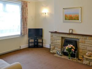 a living room with a fireplace and a television at East Sea View in Woodhorn
