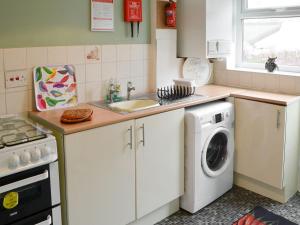 a kitchen with a sink and a washing machine at East Sea View in Woodhorn