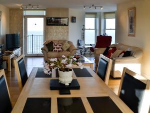 - un salon avec une table et des fleurs dans l'établissement Apartment 6, à Ilfracombe