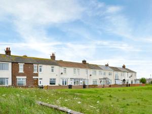 a row of houses on a grass field at East Sea View in Woodhorn
