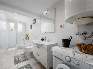 biała łazienka z umywalką i pralką w obiekcie Casa Astrid w Poreču