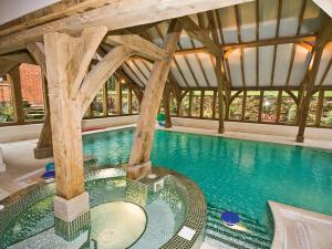 a swimming pool in a building with a large swimming pool at Brankley Cottage - E4712 in Dunstall