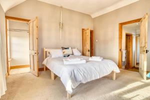 um quarto com uma cama grande e lençóis brancos em Pass the Keys Family home in the countryside em Lincoln