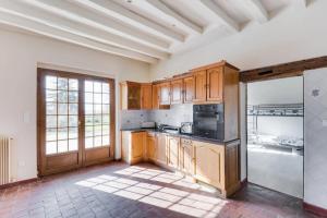 uma cozinha com armários de madeira e um forno com placa de fogão em Crazy Villa Etisseaux 45 - Heated pool - Volley court - 1h30 Paris - 45p em Saint-Maurice-sur-Aveyron