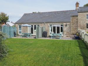 a house with a yard with two picnic tables at The Granary in Dunvant