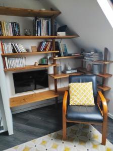 a living room with a chair and a book shelf at Le studio d'Evelyne in Dieppe