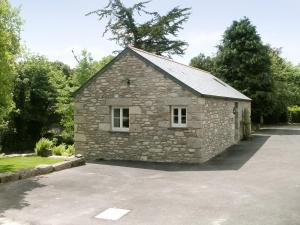 a stone building with two windows in a parking lot at The Barn in Carleen