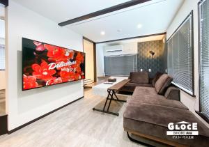 a living room with a couch and a large screen tv at GLOCE ゲストハウス丘宿 l 高台から美幌町を一望できる一軒家を貸切 無料駐車場有 in Bihoro