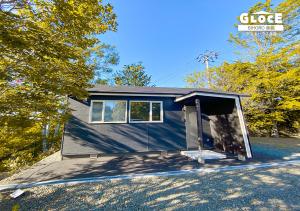 a tiny house with a garage on a lot at GLOCE ゲストハウス丘宿 l 高台から美幌町を一望できる一軒家を貸切 無料駐車場有 in Bihoro