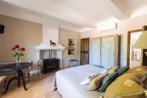 a bedroom with a bed and a desk and a fireplace at Le Mas Silvestre in Saint-Saturnin-dʼApt