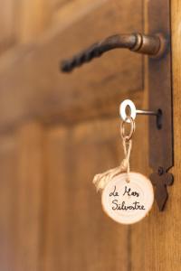a key tag on a wooden door with the words a new substance at Le Mas Silvestre in Saint-Saturnin-lès-Apt