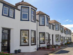 a row of white houses with blue windows at Blair Terrace in Portpatrick