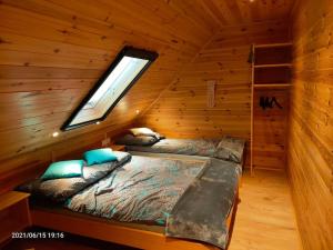 a bedroom with a bed in a log cabin at Wakacyjne Zacisze in Rusinowo