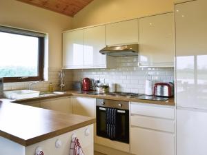 a kitchen with white cabinets and a counter top at Bulrush Lodge in Burgh le Marsh