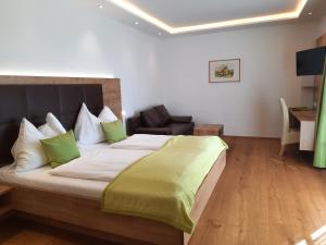 a bedroom with a large bed and a chair at Landhaus Ferk in Bad Radkersburg
