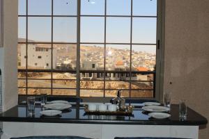 a dining room with a table with a large window at Treasury Terrace Apartments in Wadi Musa