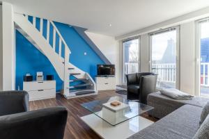 d'un salon avec des murs bleus et un escalier. dans l'établissement Achtern-Poggendiek-Storchenhorst-OG, à Sankt Peter-Ording