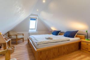 - une chambre avec un lit doté d'oreillers bleus et d'une chaise dans l'établissement Achtern-Poggendiek-Storchenhorst-OG, à Sankt Peter-Ording