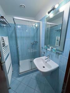W łazience znajduje się szklana kabina prysznicowa i umywalka. w obiekcie Hotel Apollon w Litomierzycych