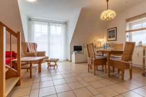 a living room with a dining room table and chairs at FeWo-Salzwiesen in Süderhöft