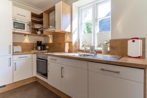 a kitchen with white cabinets and a sink and a window at Haus-Molina in Böhl