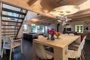 a kitchen and dining room with a wooden table and chairs at HYGGE-unter-Reet in Westerhever