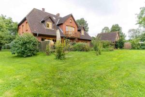 una casa grande en un patio con césped verde en Hohe-Duene, en Vollerwiek