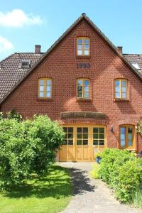 una gran casa de ladrillo con puerta amarilla en Hohe-Duene, en Vollerwiek
